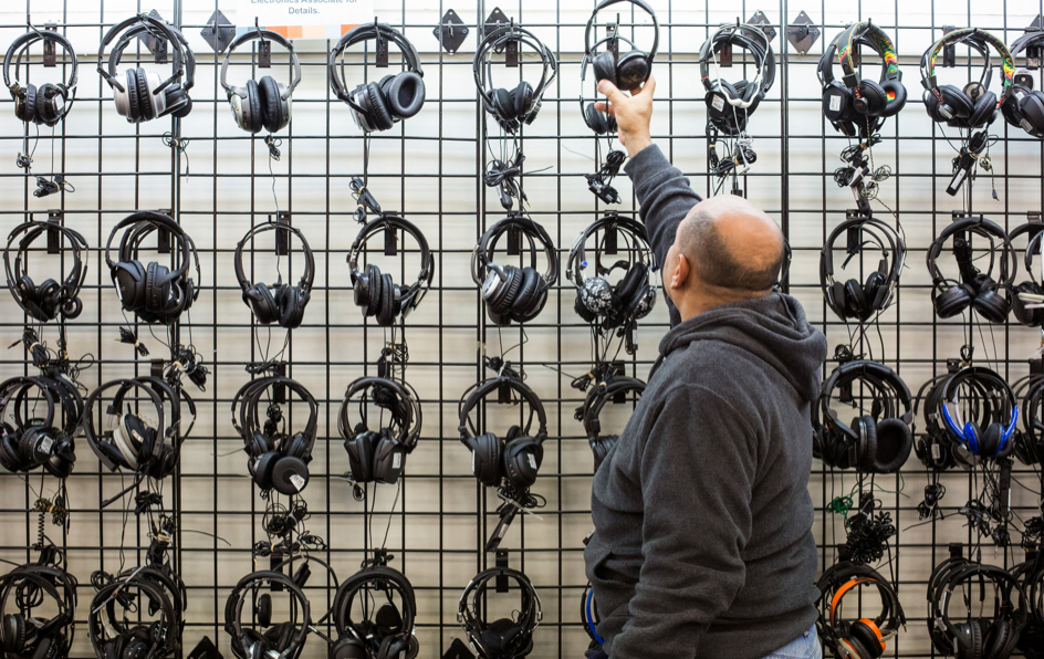 a man looking at headphones on a wall