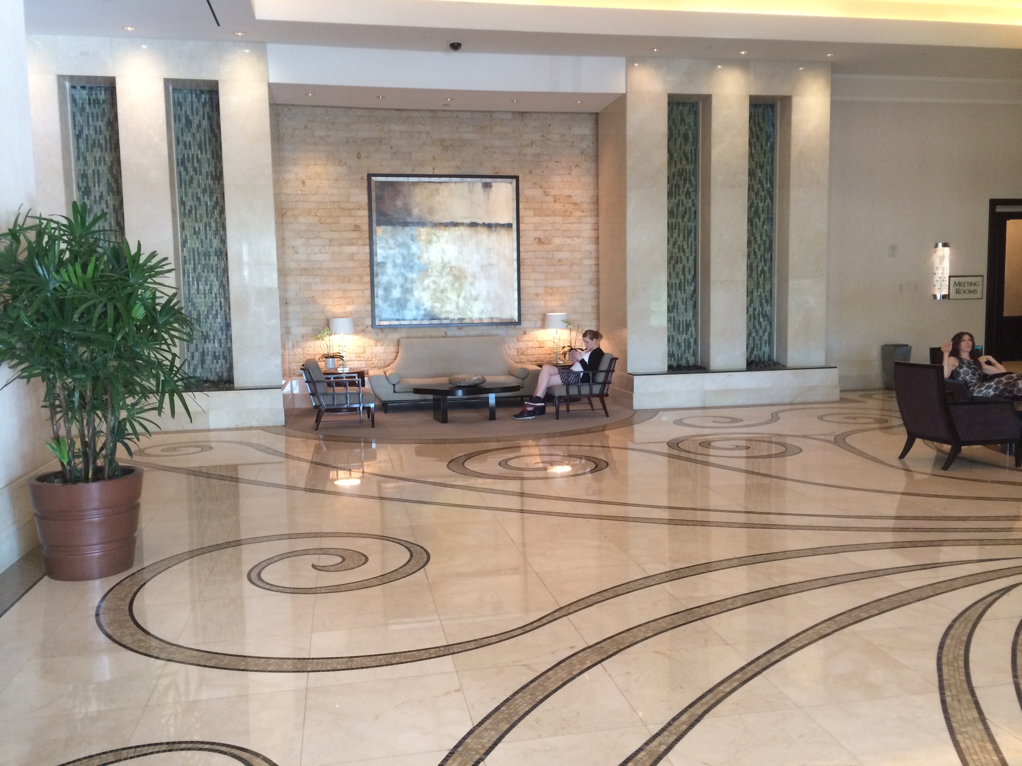 a large lobby with a large tiled floor and a large painting on the wall