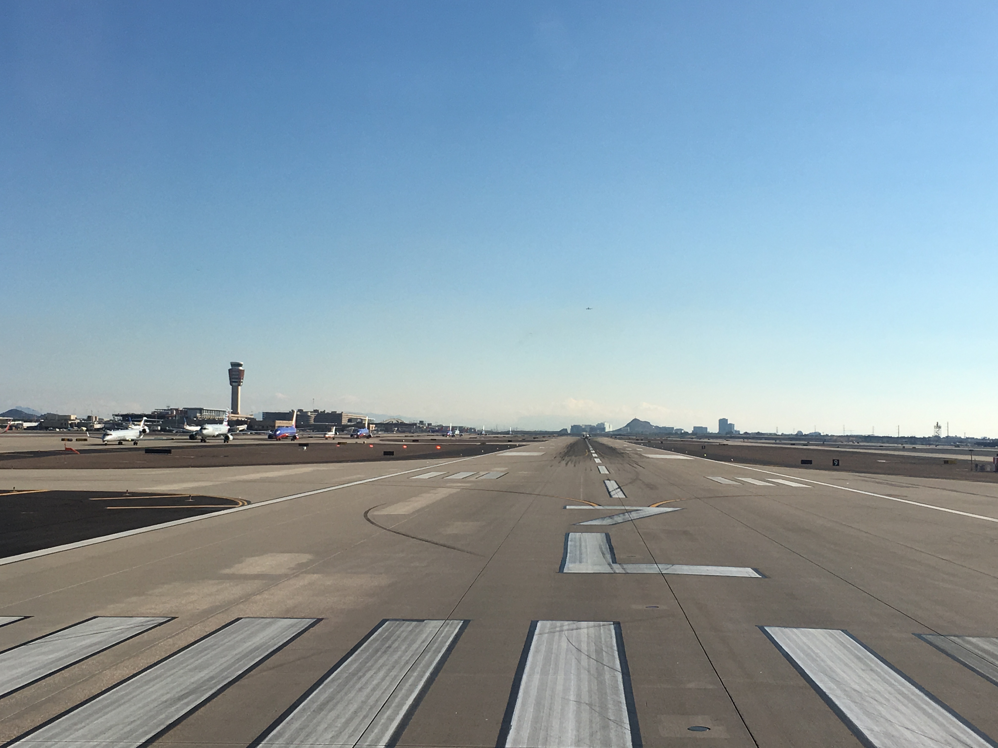 an airport runway with planes on the ground