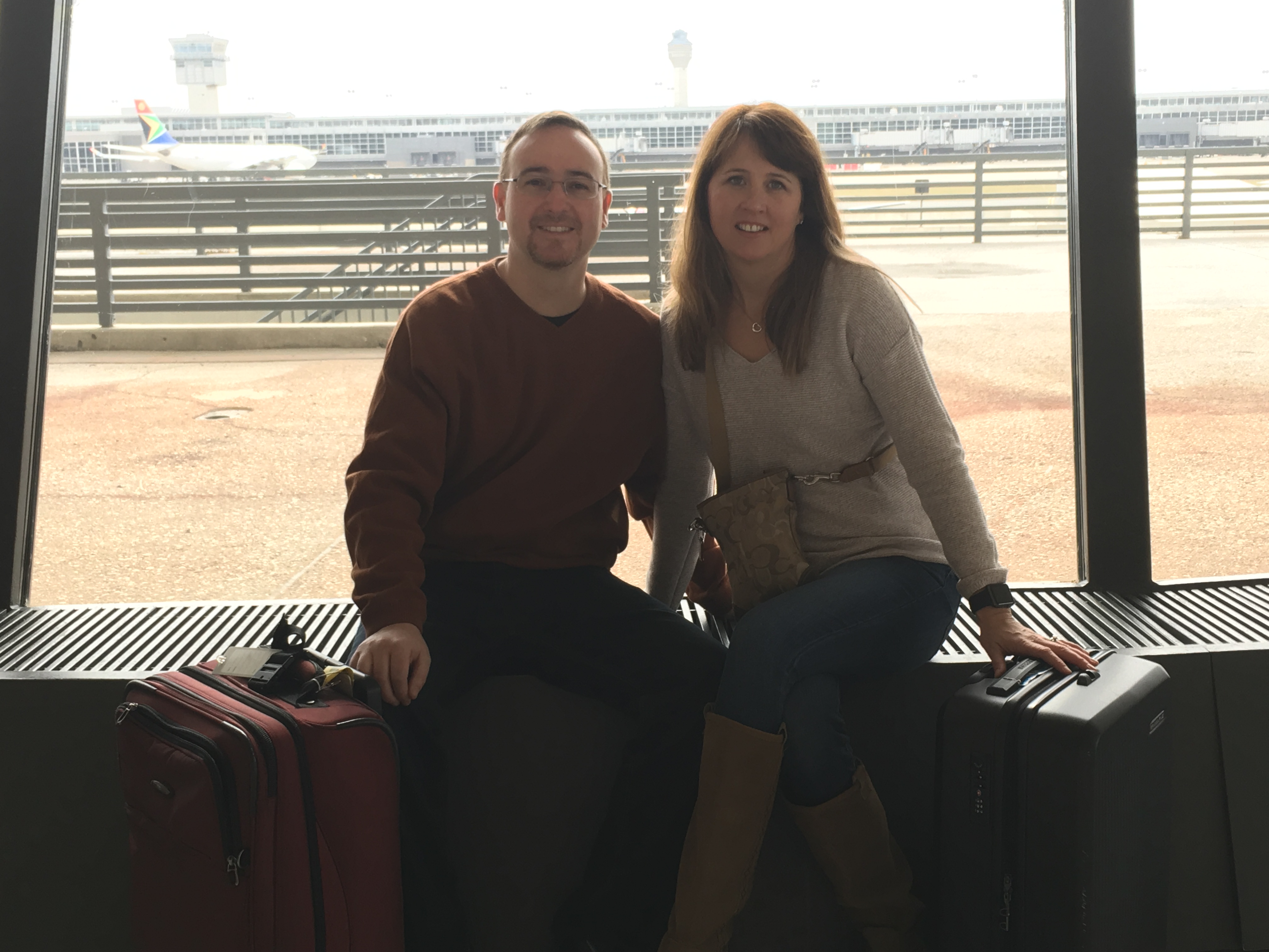 a man and woman sitting on luggage