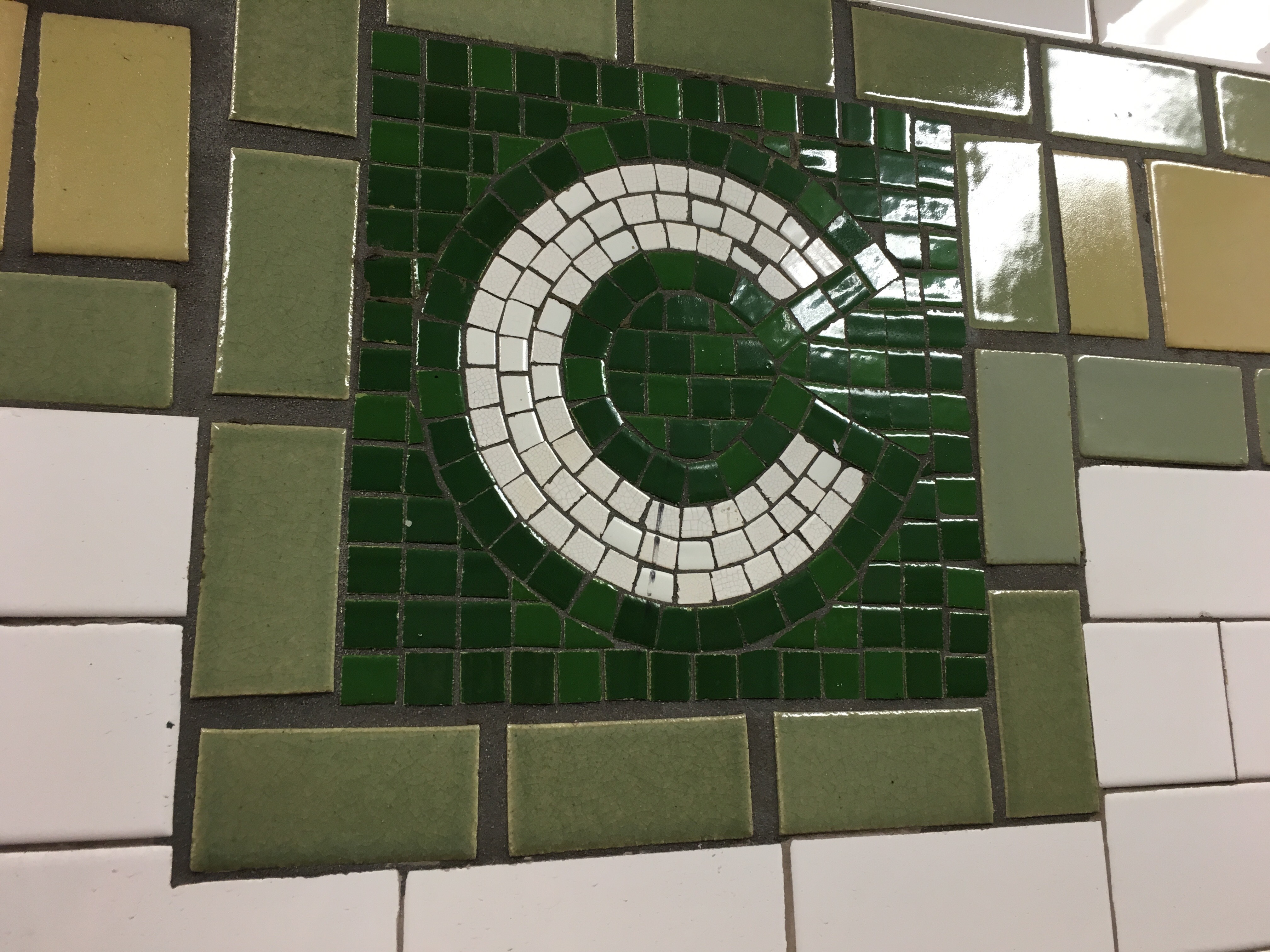 a green and white tile on a wall