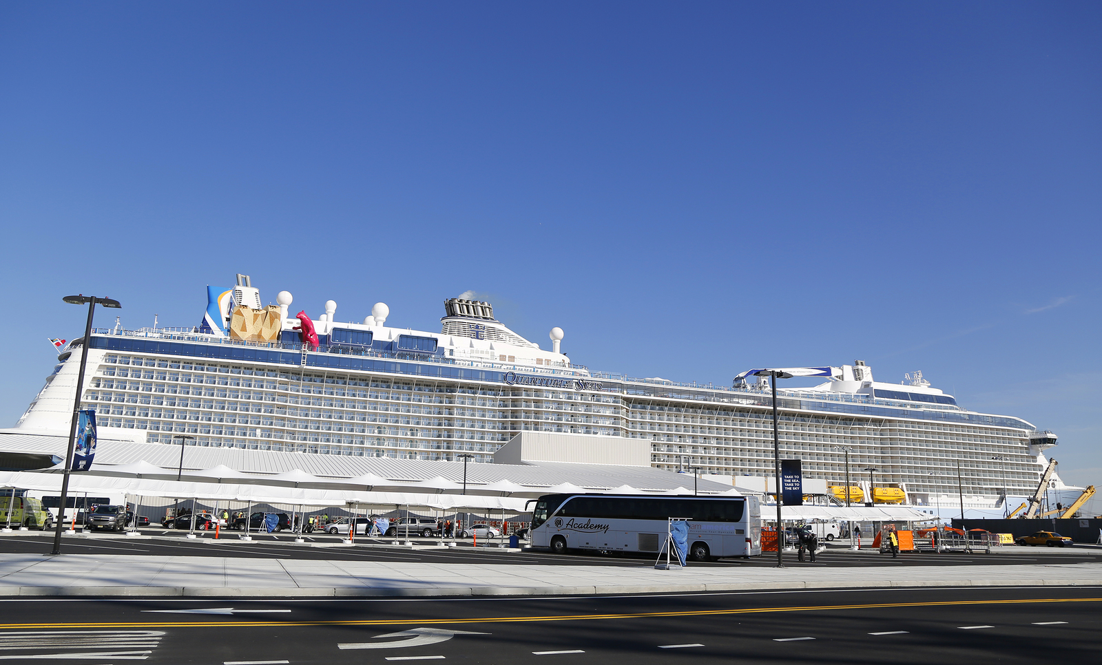 a large cruise ship with a bus parked on the side