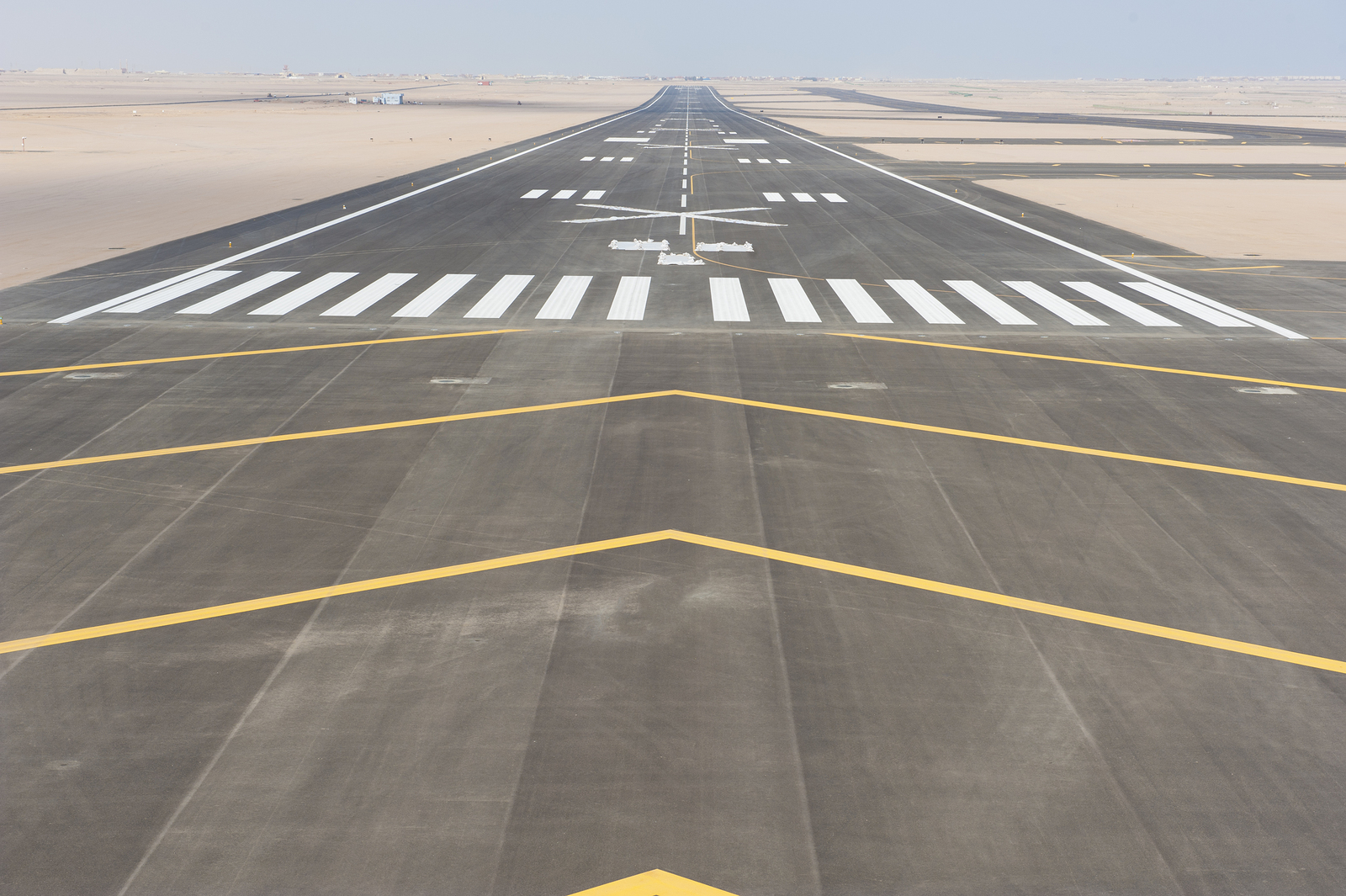 a runway with white and yellow markings