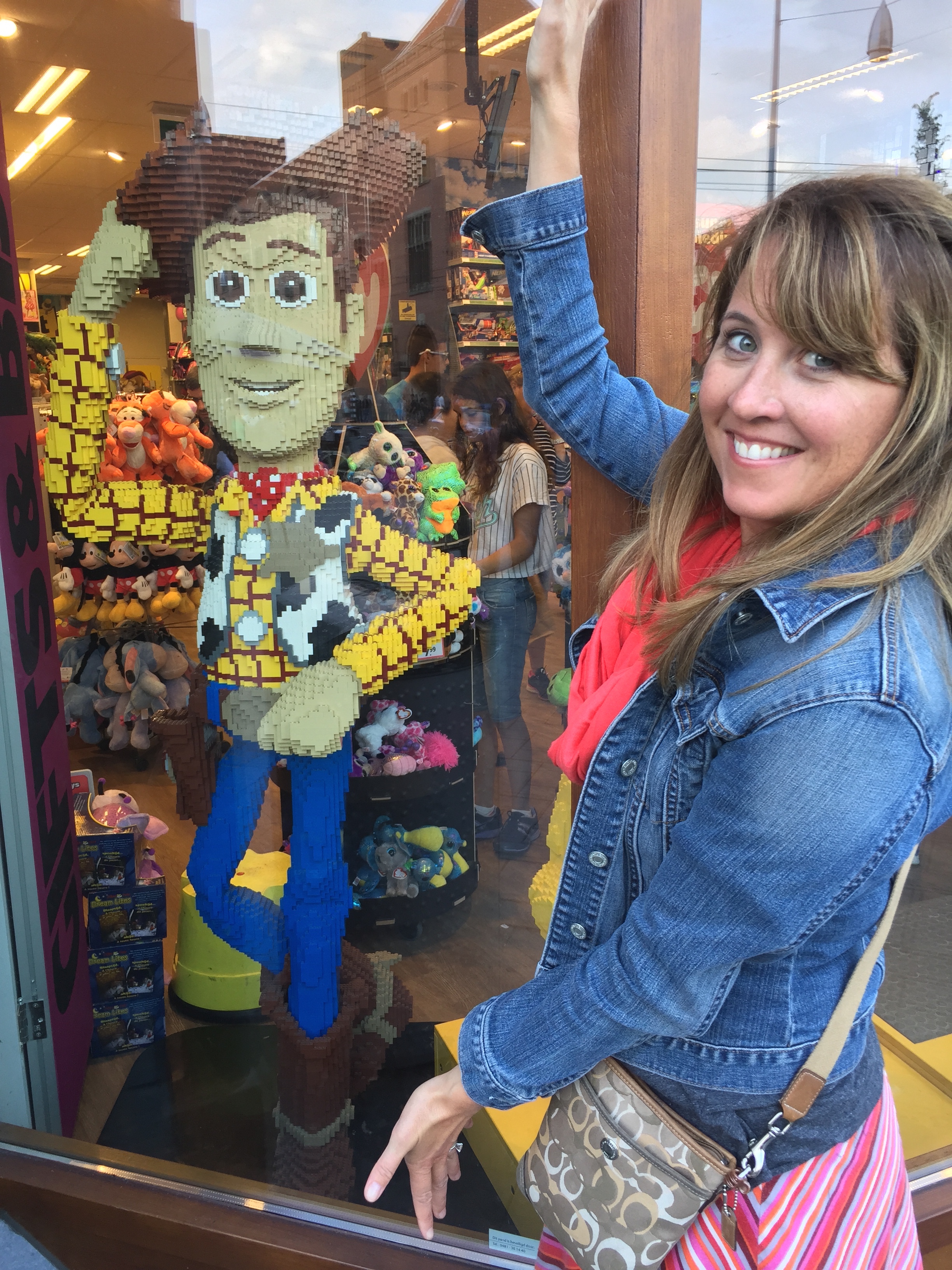 a woman standing next to a window with a toy character