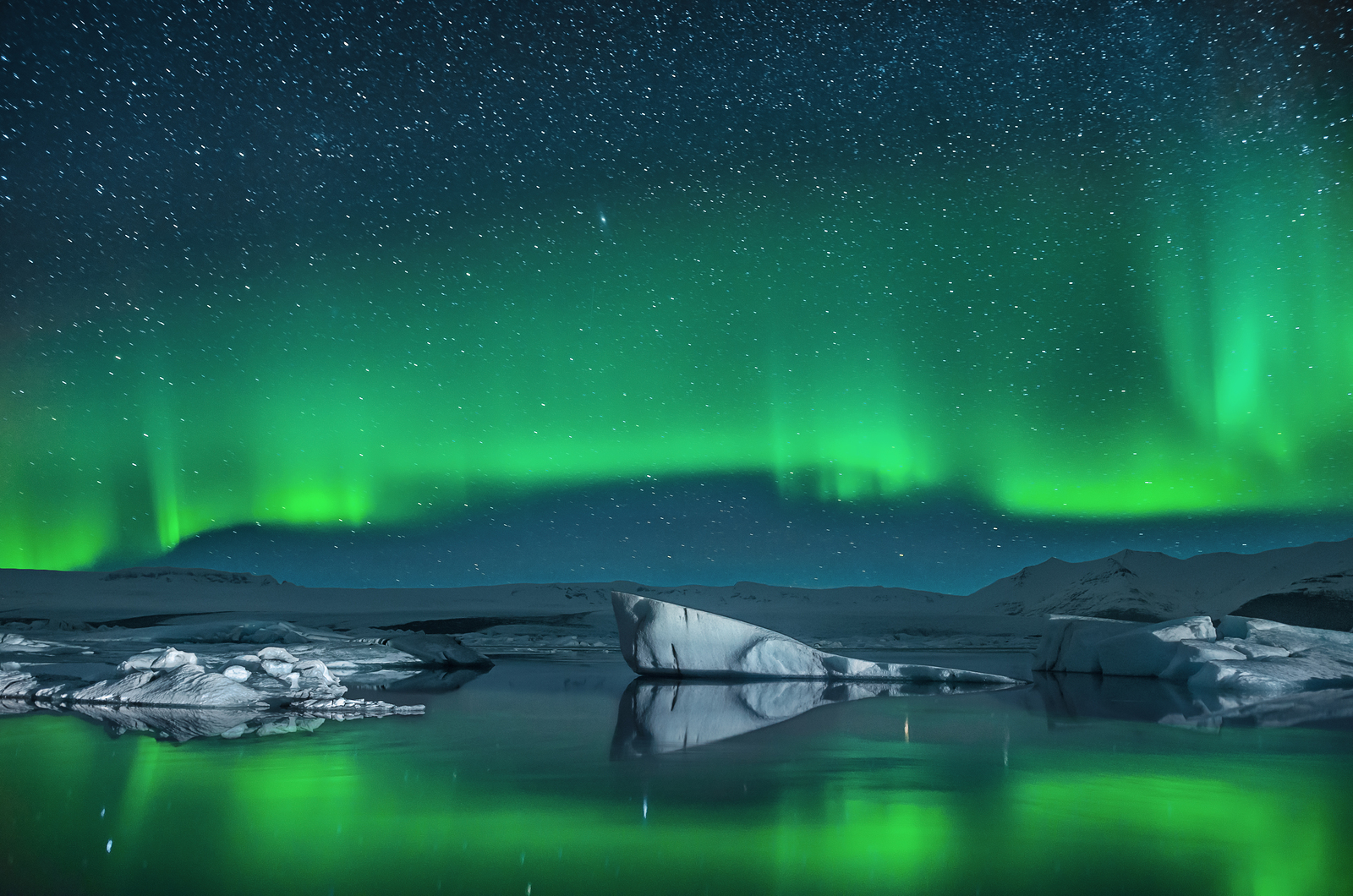 a green lights in the sky over water
