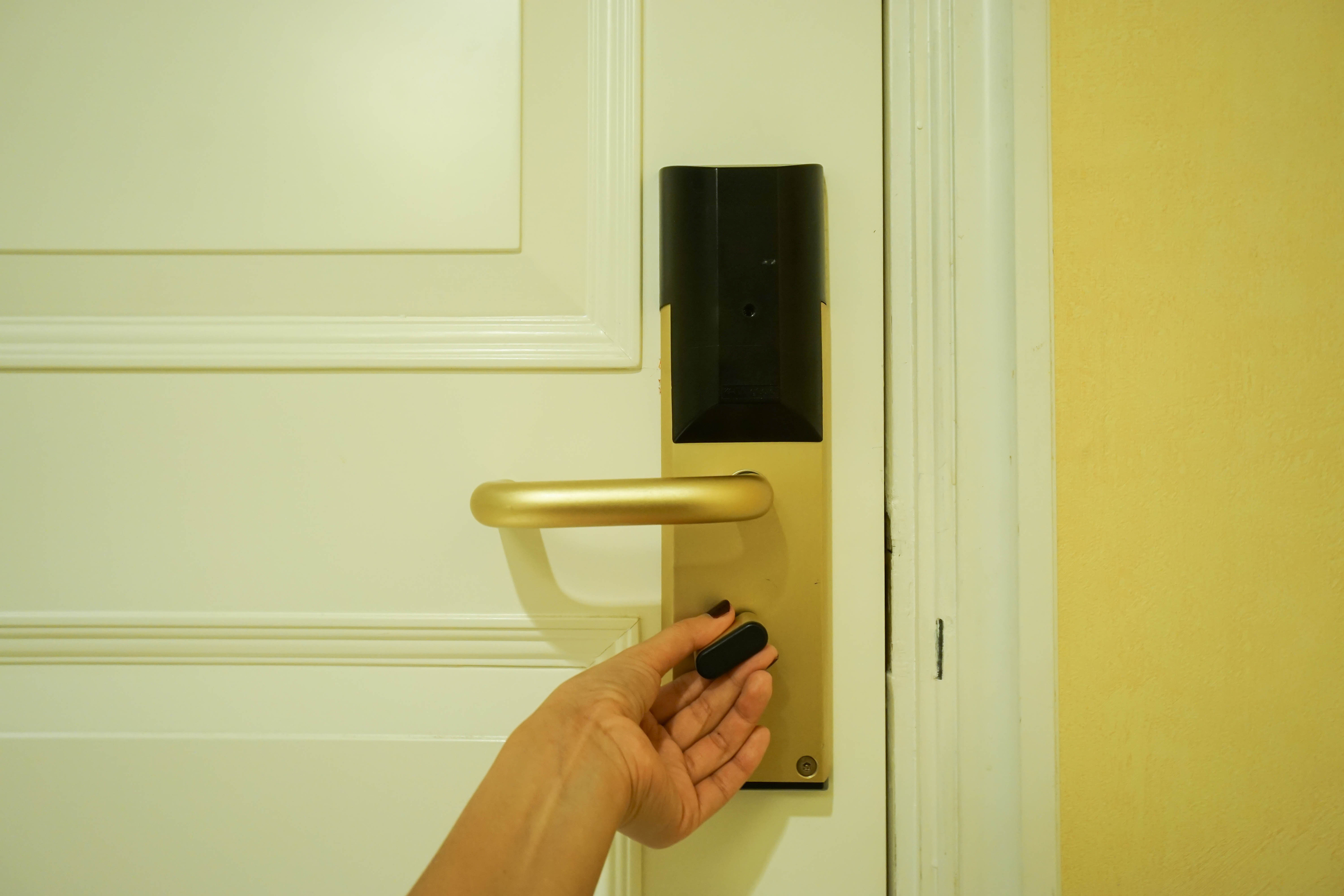 a hand holding a key to a gold door handle