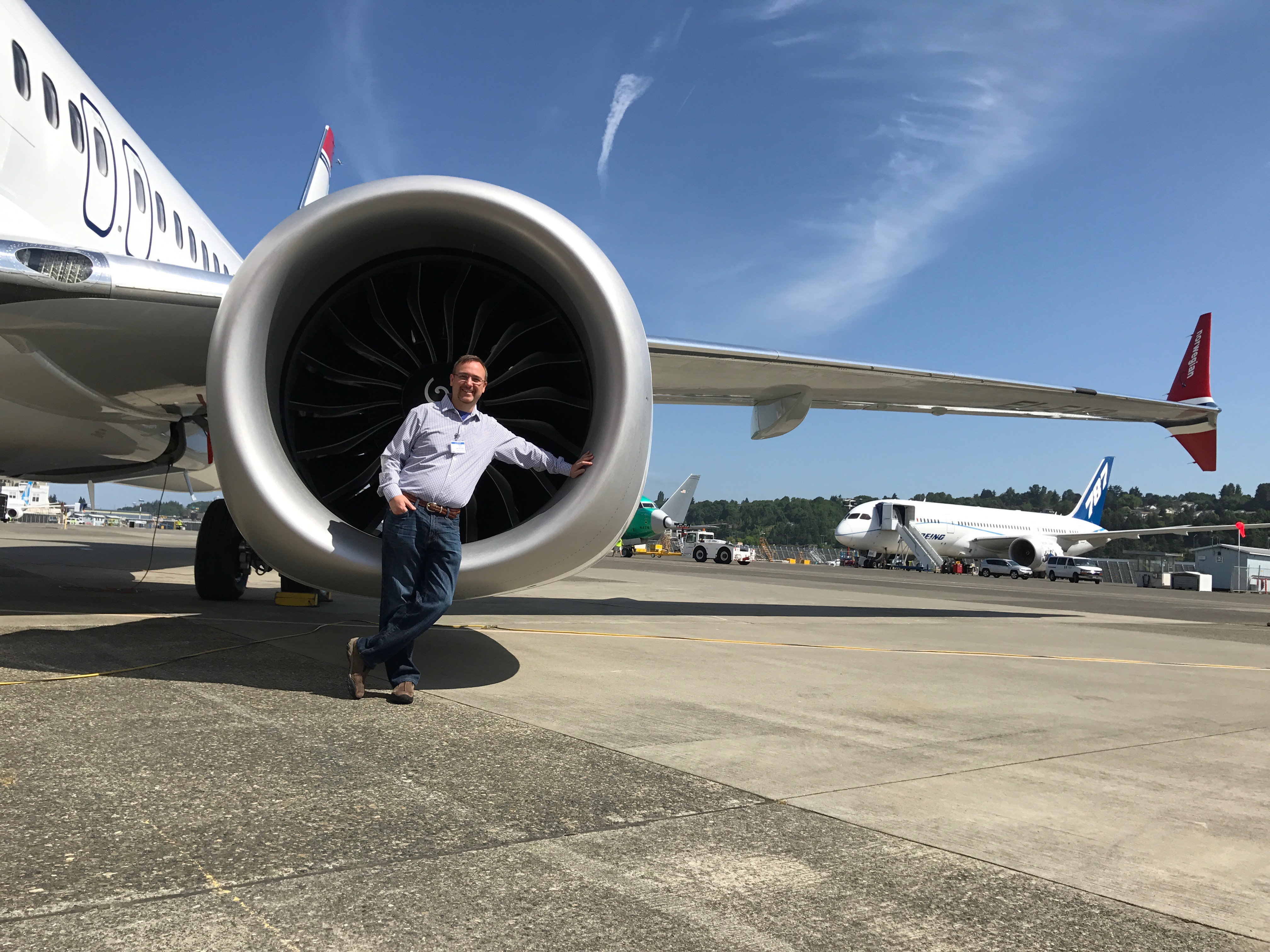 a man standing next to a large jet engine