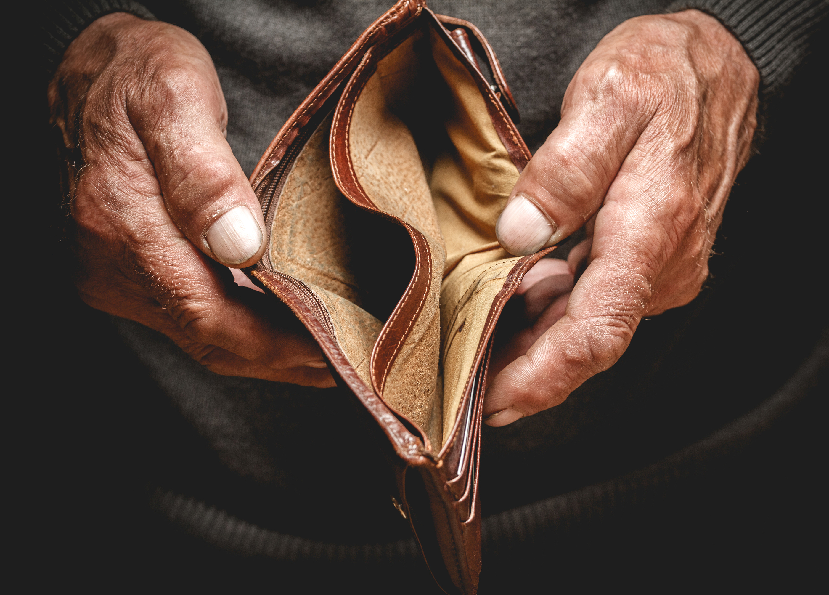an old man holding an empty wallet