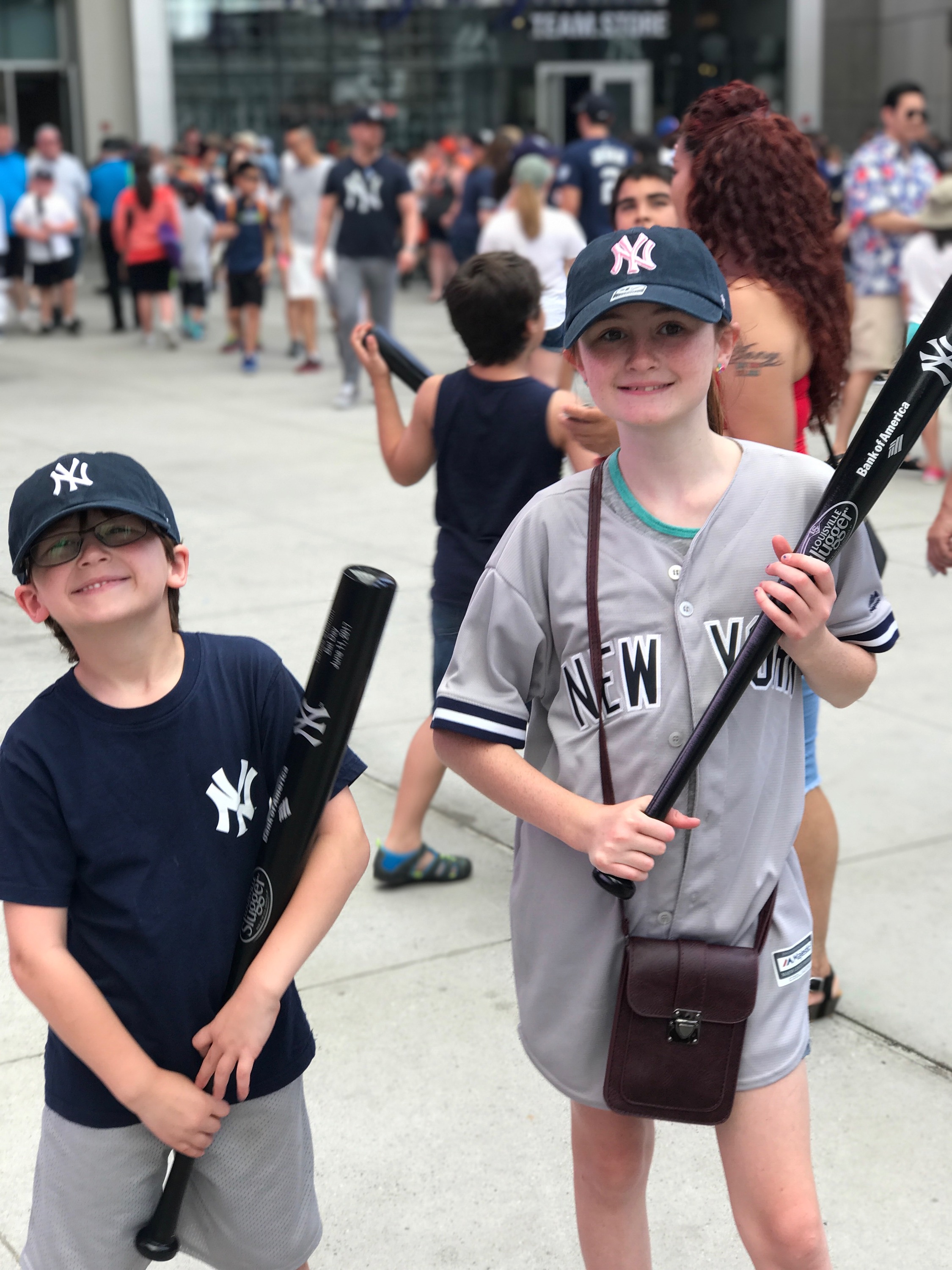 a boy and girl holding baseball bats
