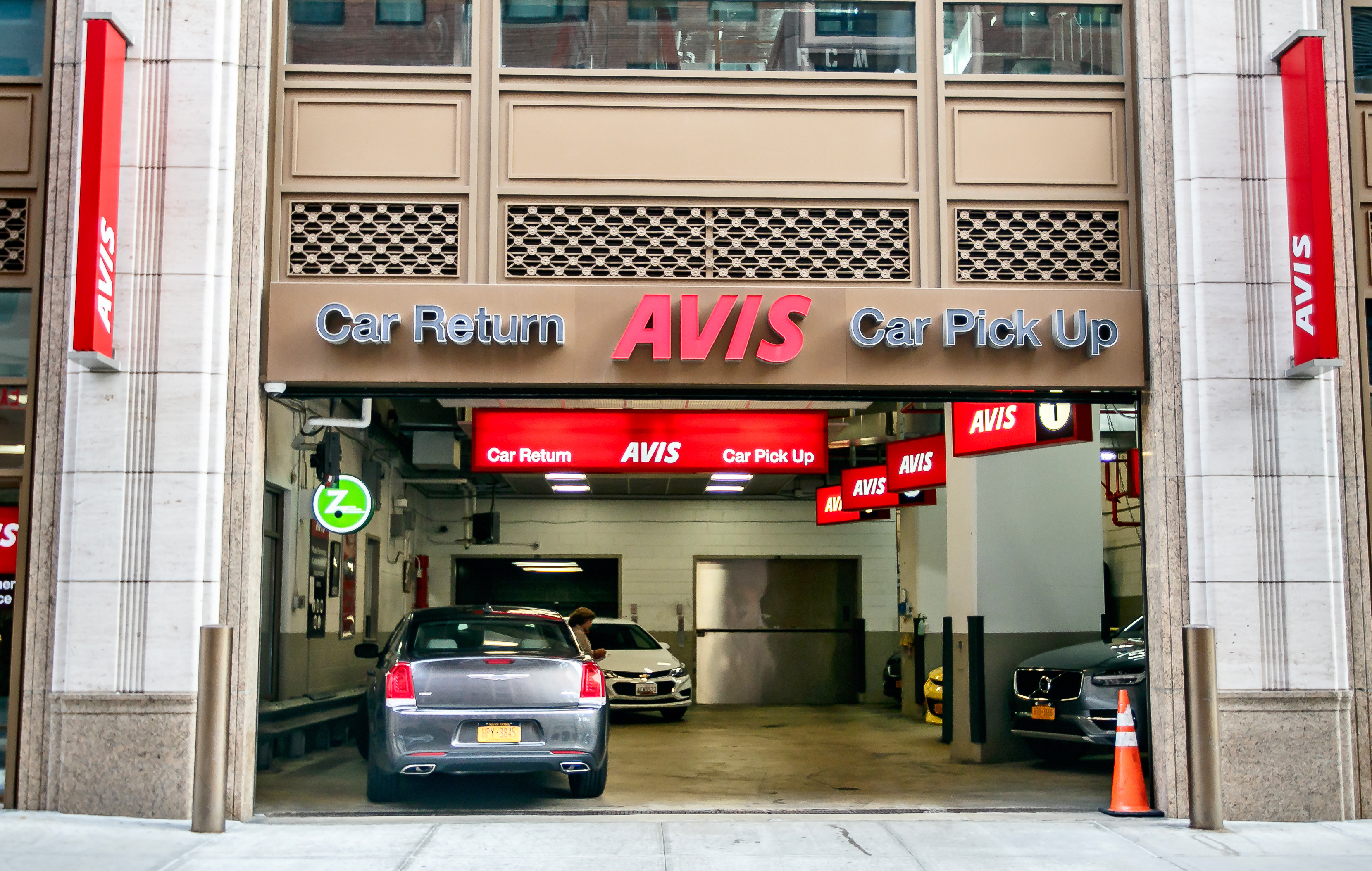 a car rental garage with cars parked in front of it