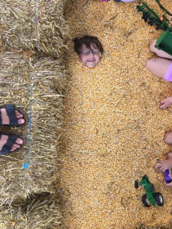 a child lying in a pile of corn