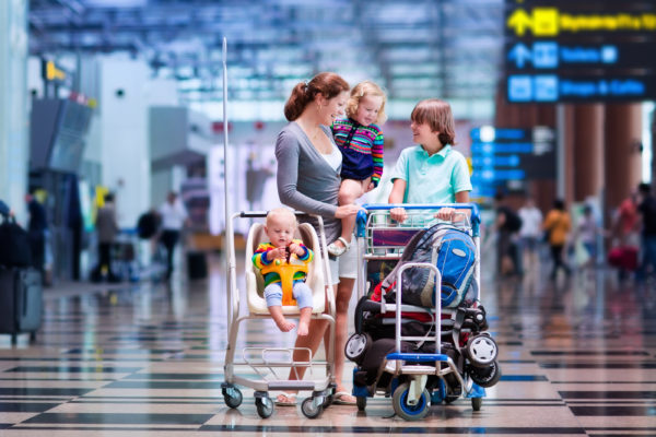 a woman and children with strollers in an airport
