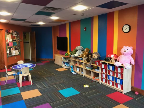 a room with a colorful wall and a table and toys