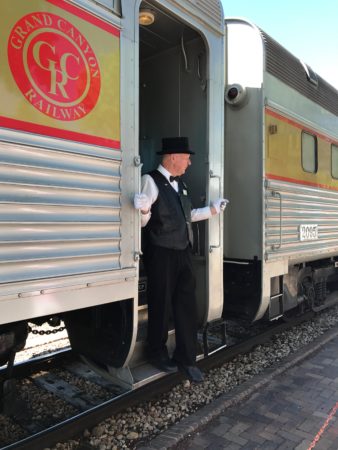 a man in a hat and gloves standing in a train
