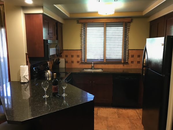 a kitchen with a counter top and wine glasses