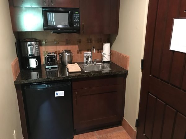 a kitchen with a black counter top and a black refrigerator