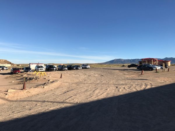a parking lot with cars and a blue sky