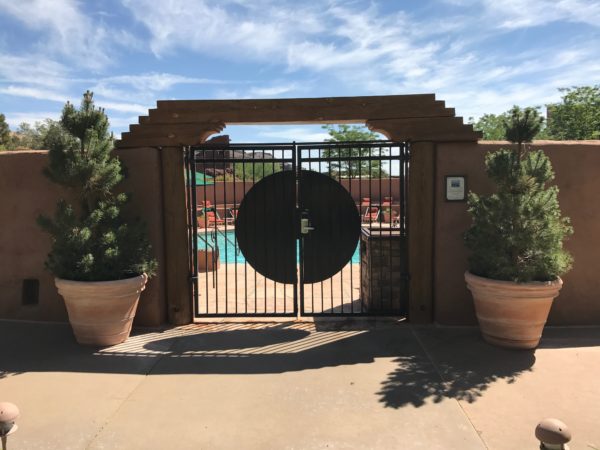 a gate with a pool in the background