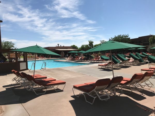 a pool with lounge chairs and umbrellas