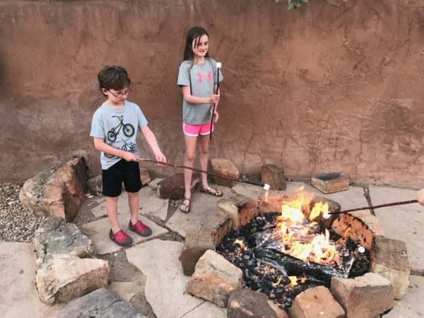 a couple of kids roasting marshmallows over a fire