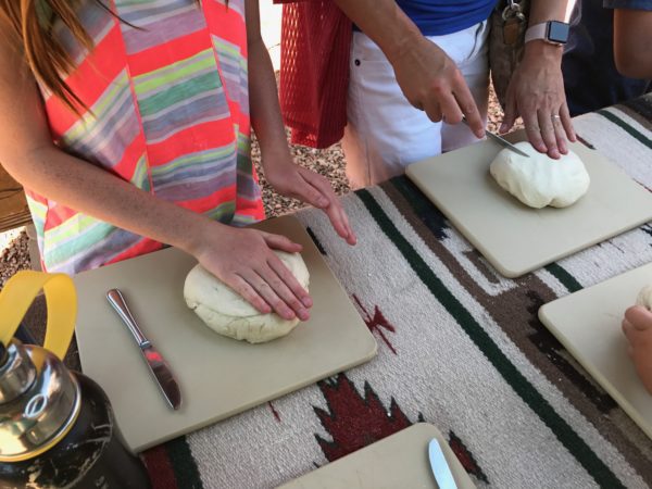 a person's hands cutting dough on cutting boards