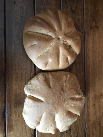 two round breads on a wooden surface