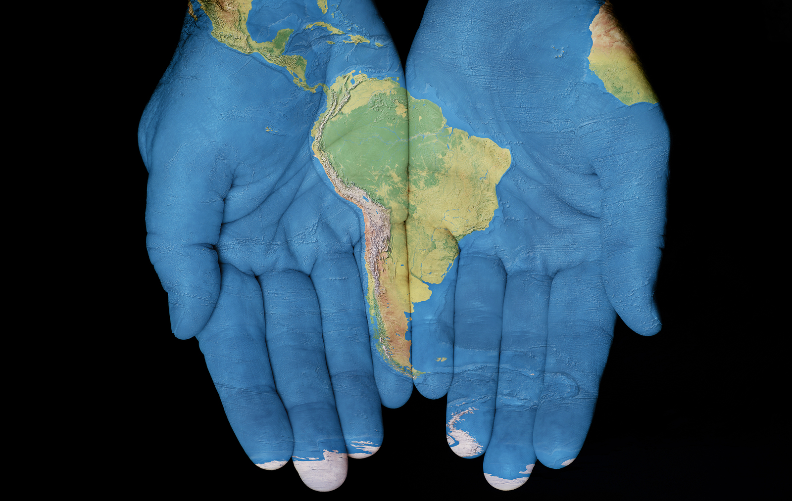 a pair of hands with a map of the world