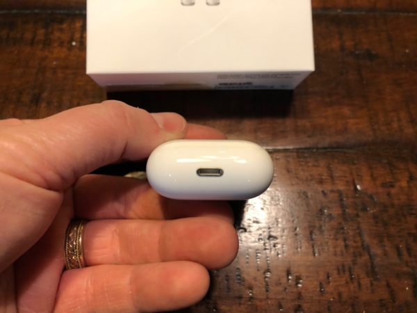 a hand holding a white earbud