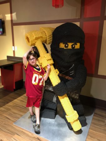 a child standing next to a lego figure