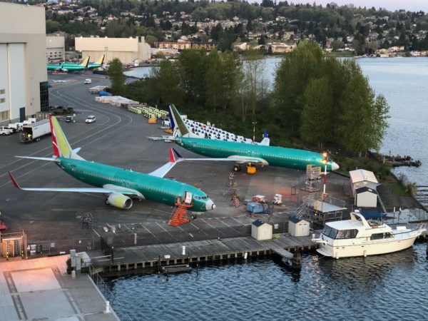 a group of airplanes parked on a dock next to a body of water