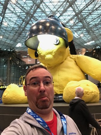 a man taking a selfie with a yellow stuffed bear