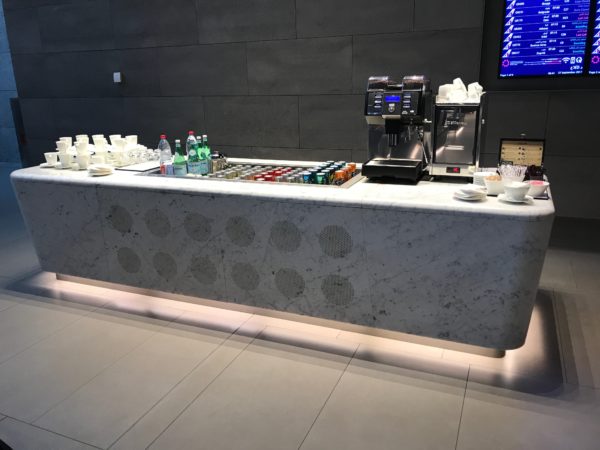 a counter with drinks and coffee machines