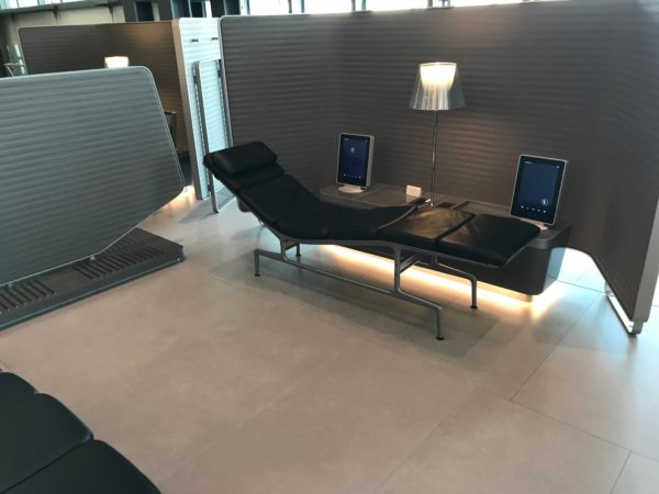 a lounge chair with a lamp and a table