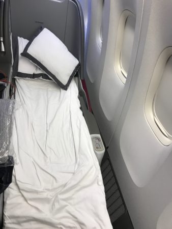 a bed with pillows and a pillow on a plane