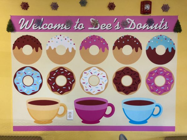 a sign with donuts and coffee cups
