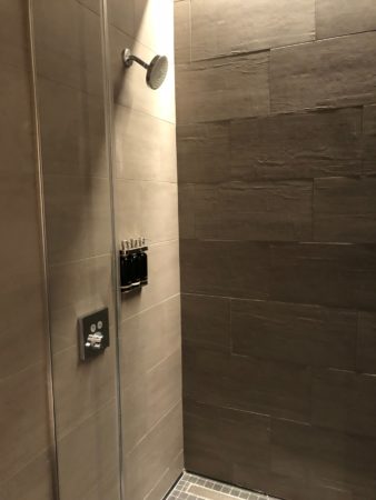 a shower with a light on the wall