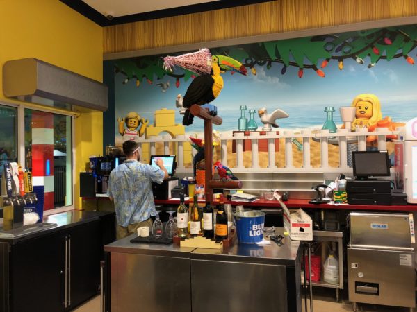 a man standing at a counter with a toucan on top