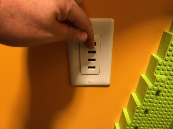 a hand turning on a wall outlet
