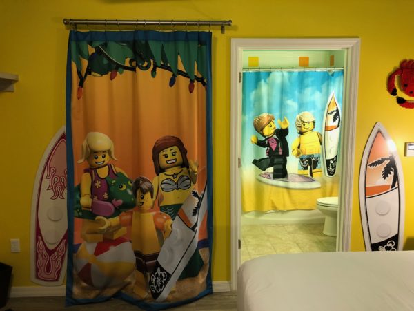 a bathroom with a yellow wall and a shower curtain