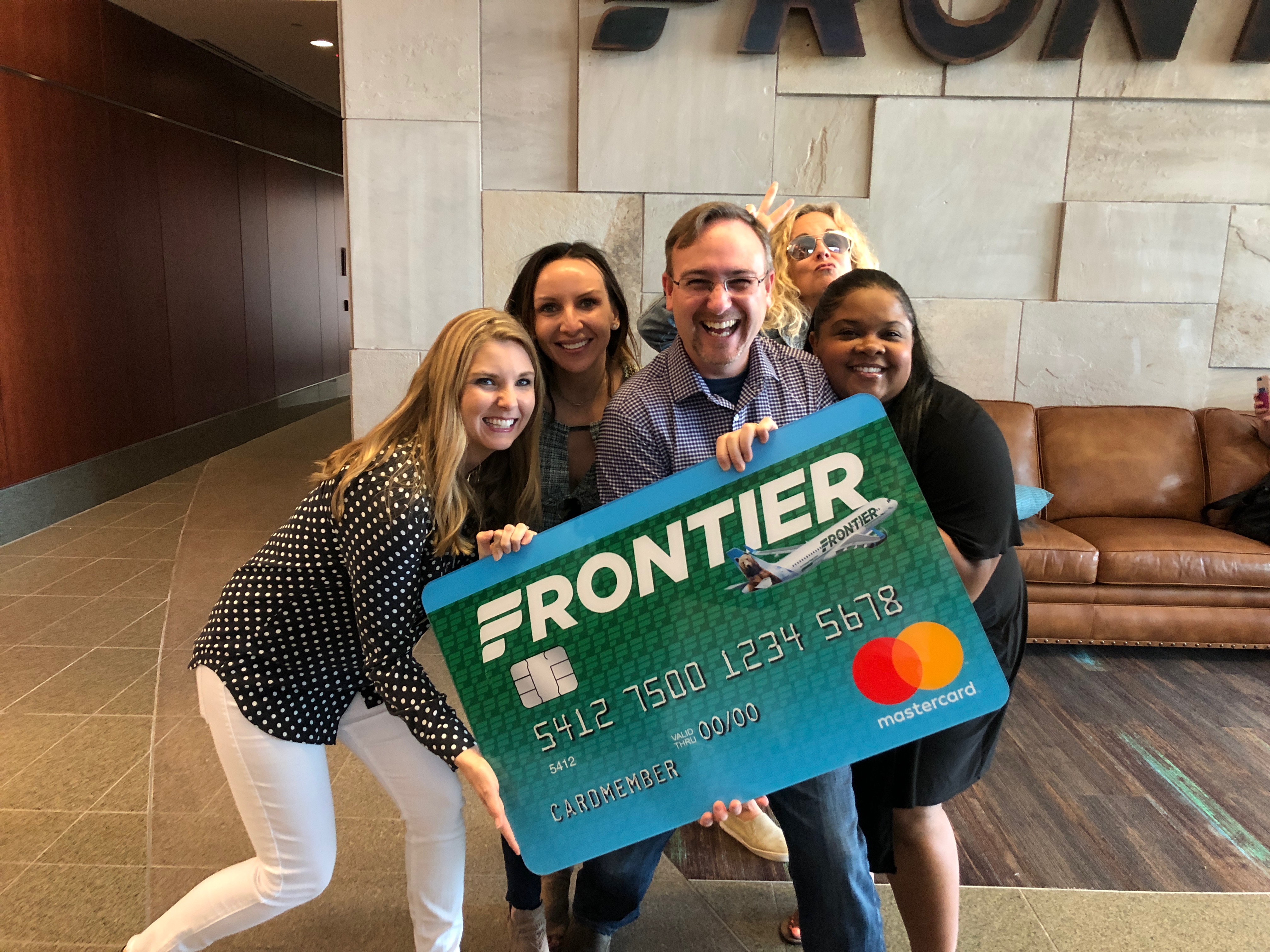 a group of people holding a large credit card