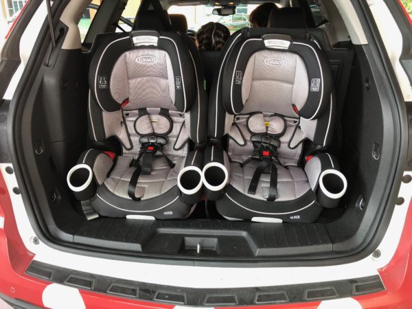 the back of a car with two baby seats