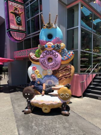 a man sitting on a chair with a doughnut statue