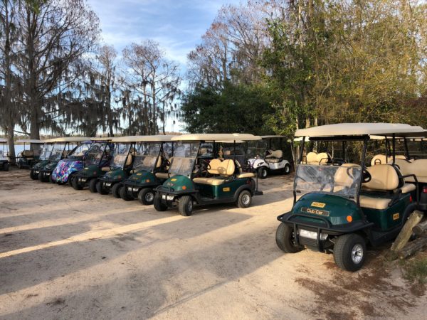 a group of golf carts parked on dirt