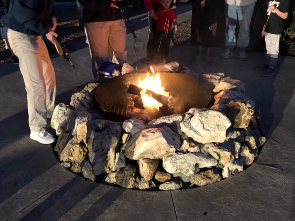 a group of people around a fire pit