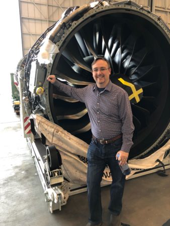 a man standing next to a large engine