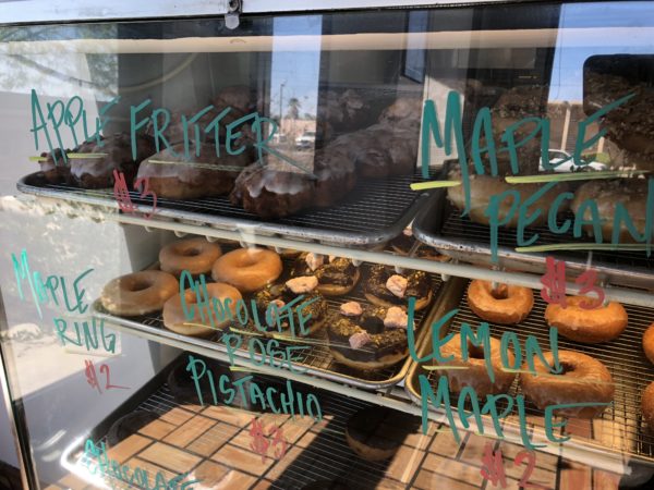 a display case with donuts on shelves