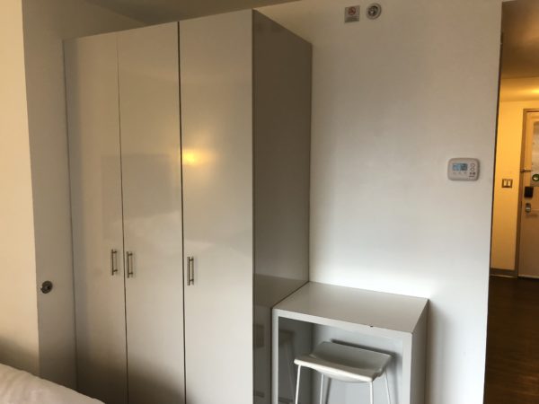 a room with white cabinets and a stool
