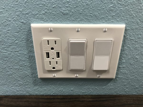 a white outlet with a couple switches on a blue wall