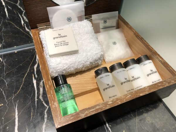 a wooden box with a variety of toiletries and towels