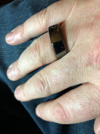 a person's hand with a black ring on it